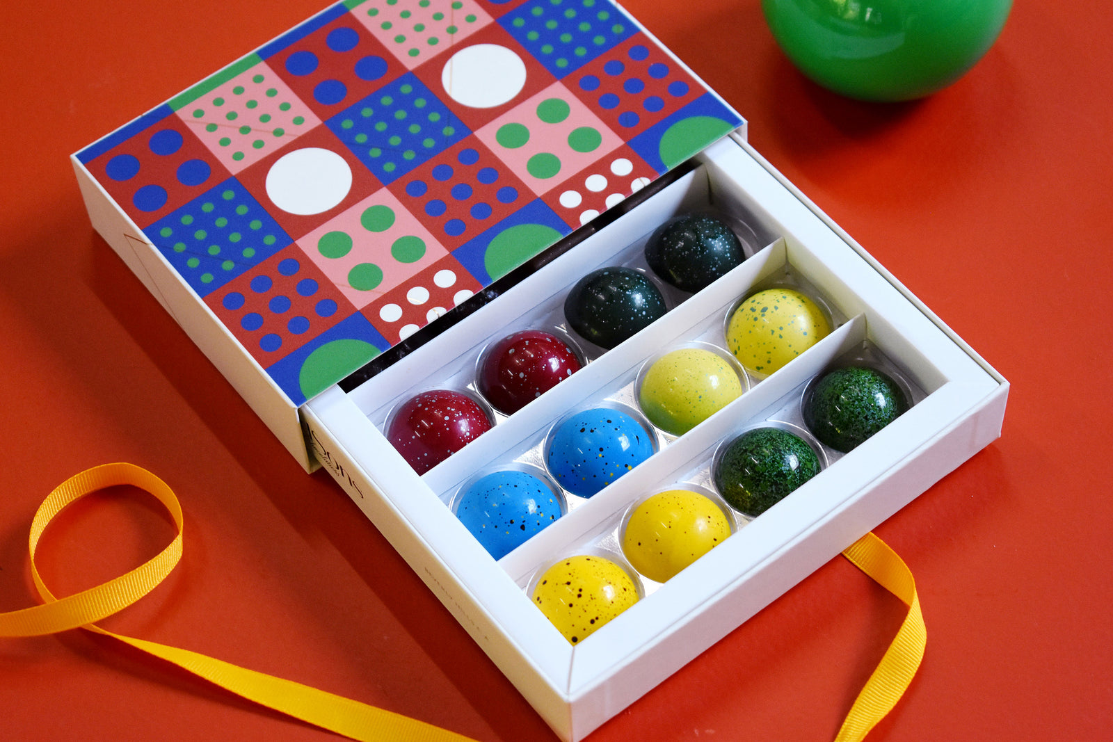 round colorful chocolates in dot pattern box