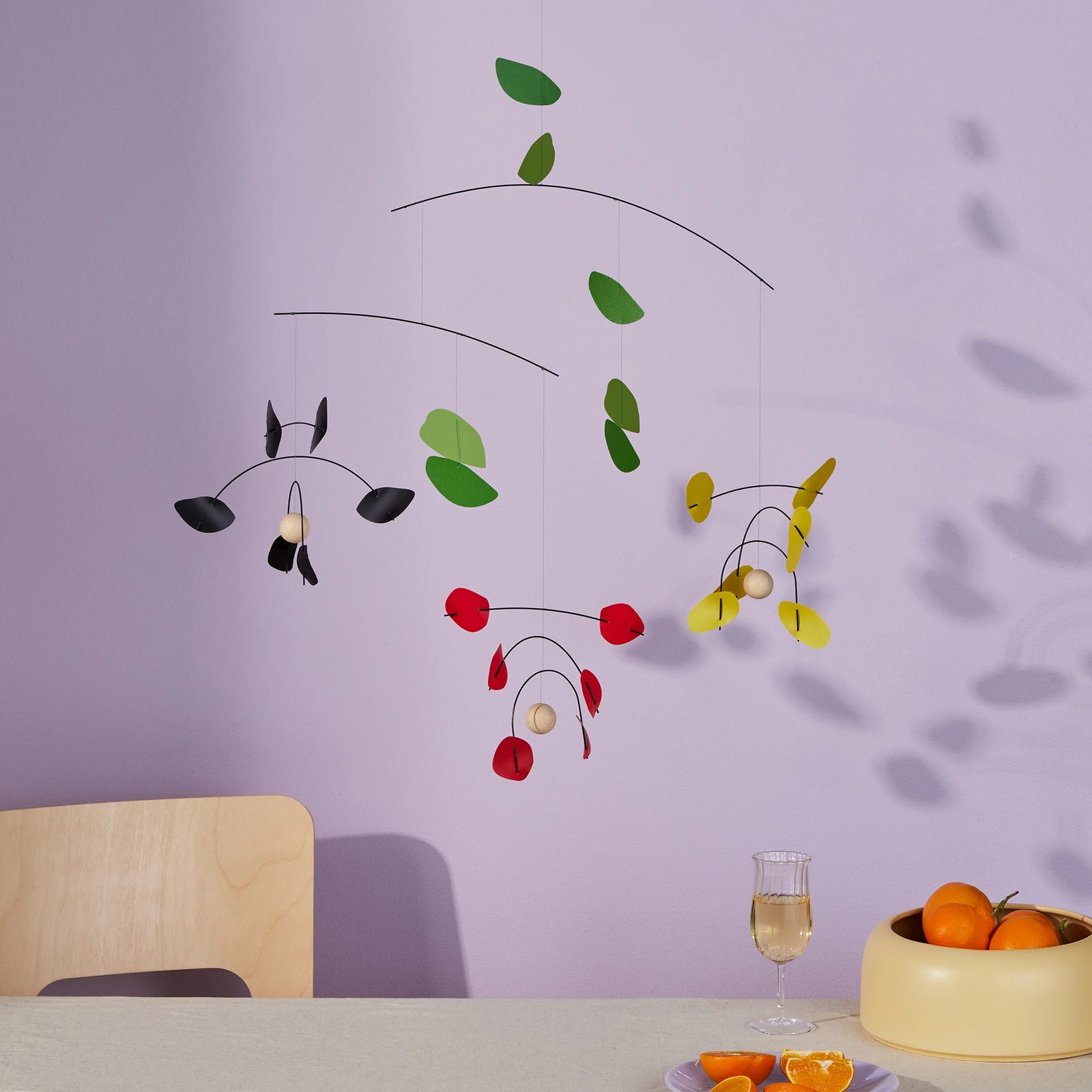 image 1 - mobile hanging with three flowers with bowl of oranges underneath