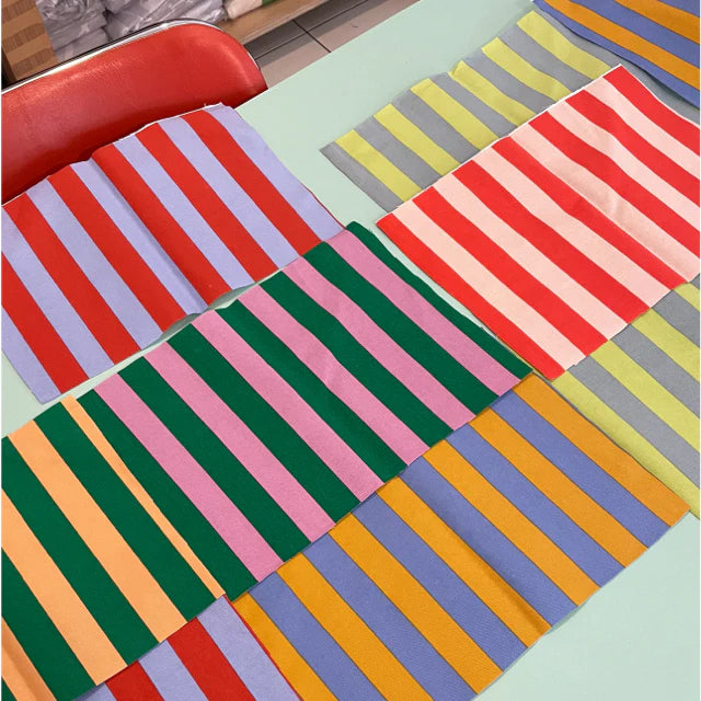 striped fabrics laid out on a table in all kinds of colors