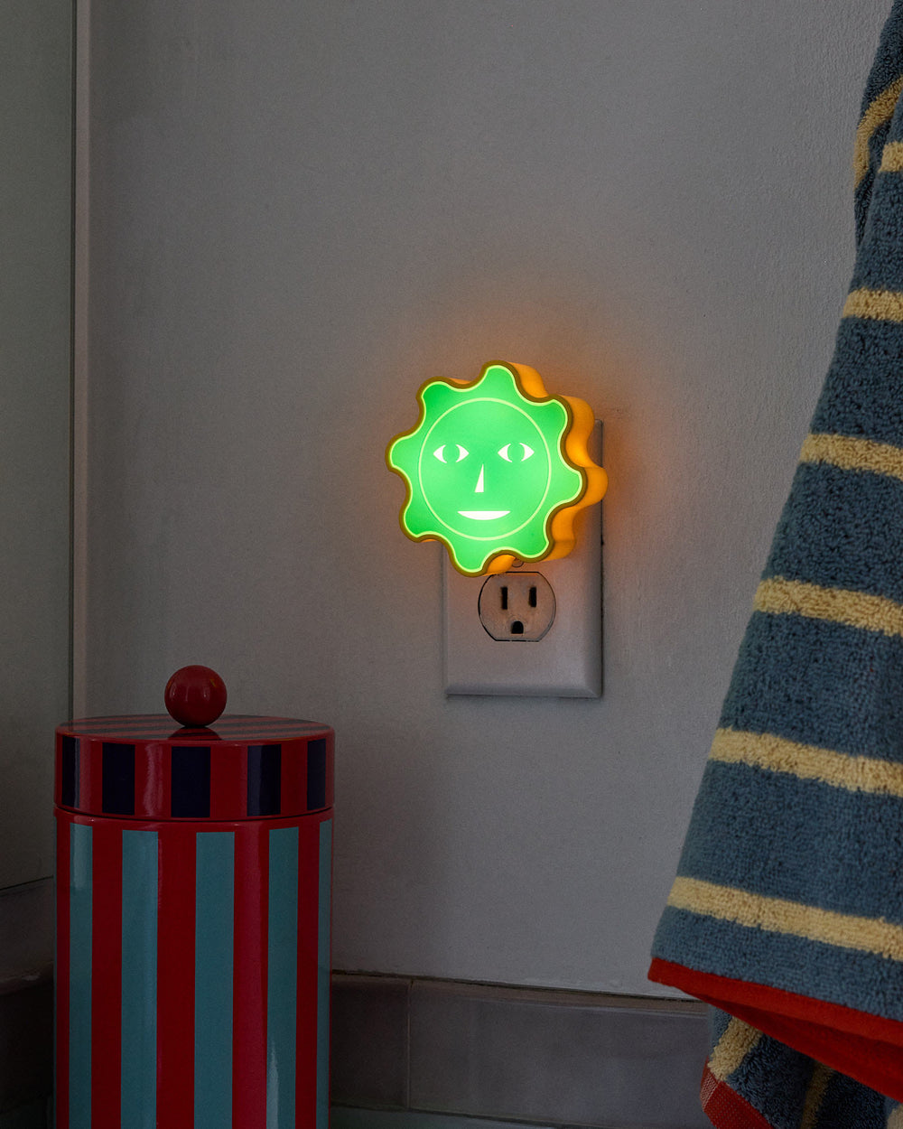 Green sun nightlight in socket in dark
