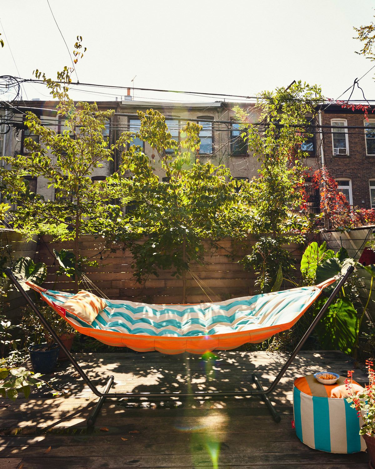 Fatboy x Dusen Dusen Outdoor Hammock in Stripe. One in Dark Brown and Orange, the other in white and blue based on the ground and sky. Stripe Hammock on deck ; Will cause an extremely snoozable area of the yard to open up <br> Comes with cover and carrier bags