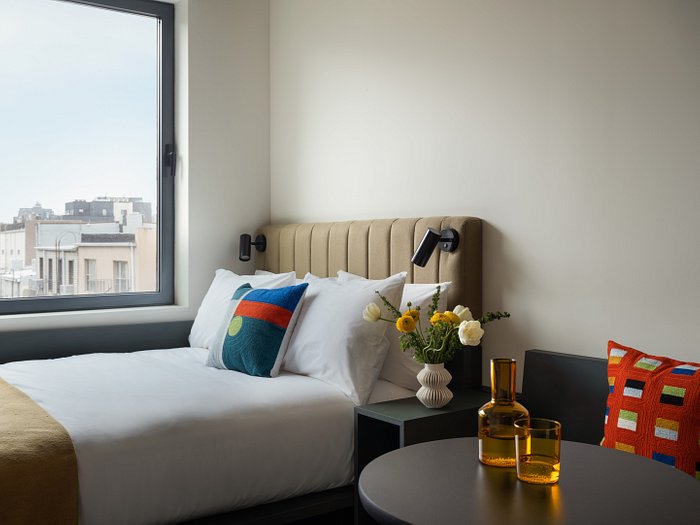 view of hotel bed with Dot pillow and dash pillow on couch
