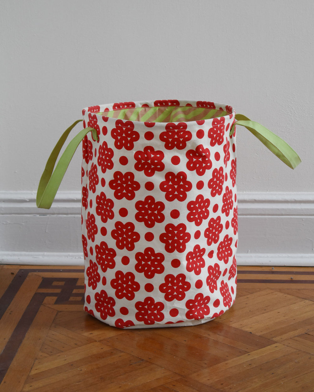 Raspberry Canvas hamper on wood floor