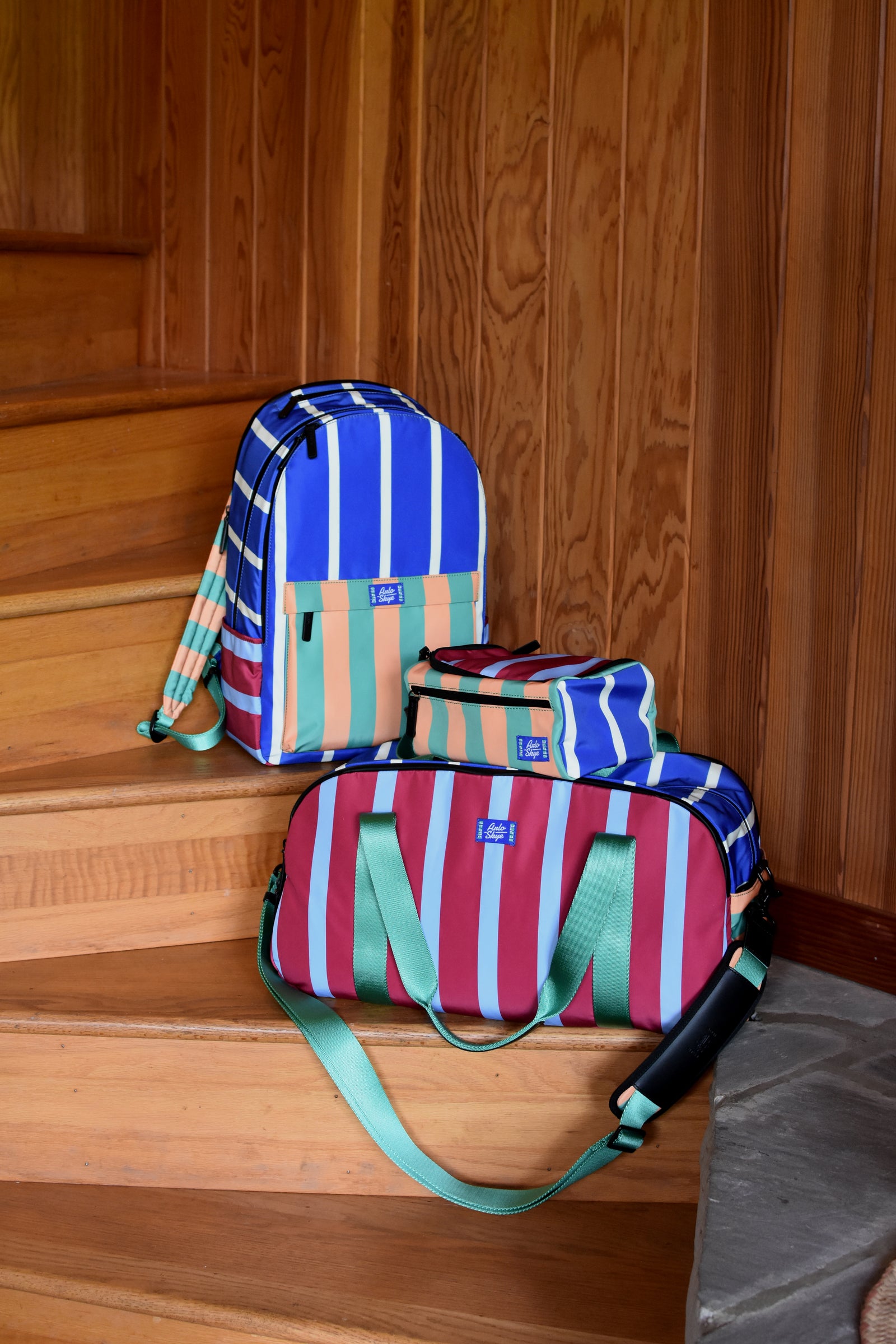 three striped bags on wooden stairs