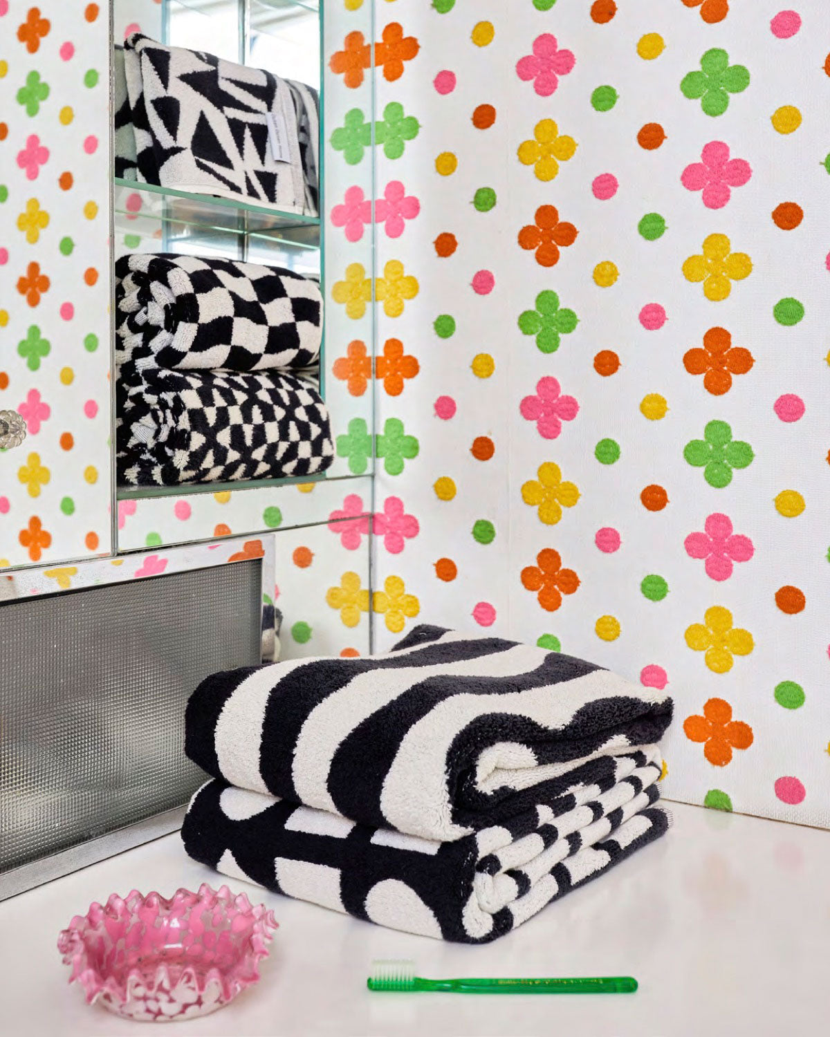 black and white towels in wallpaper bathroom