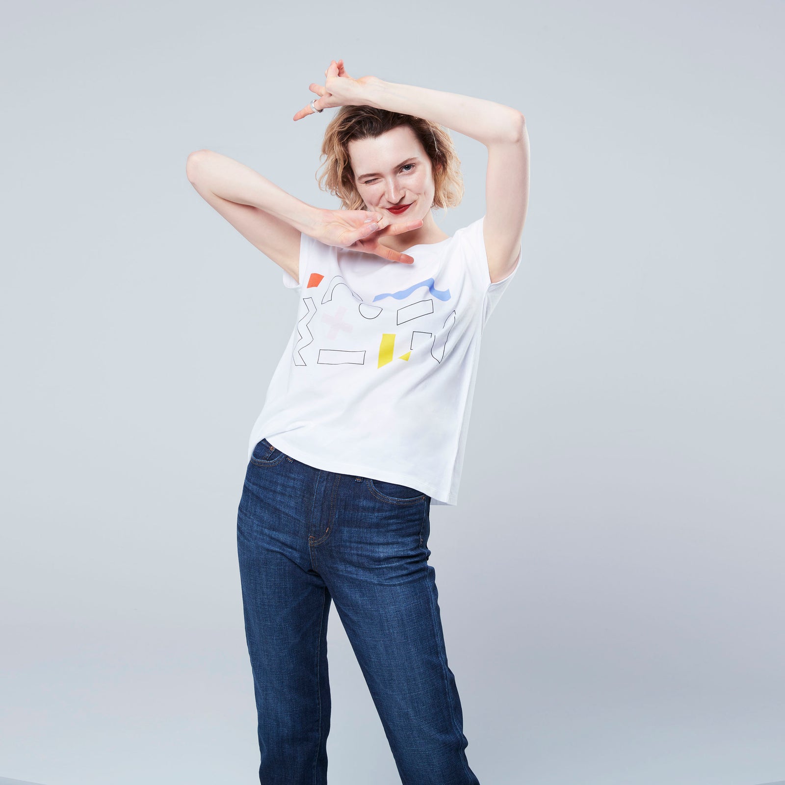 woman doing peace signs wearing pattern white t shirt