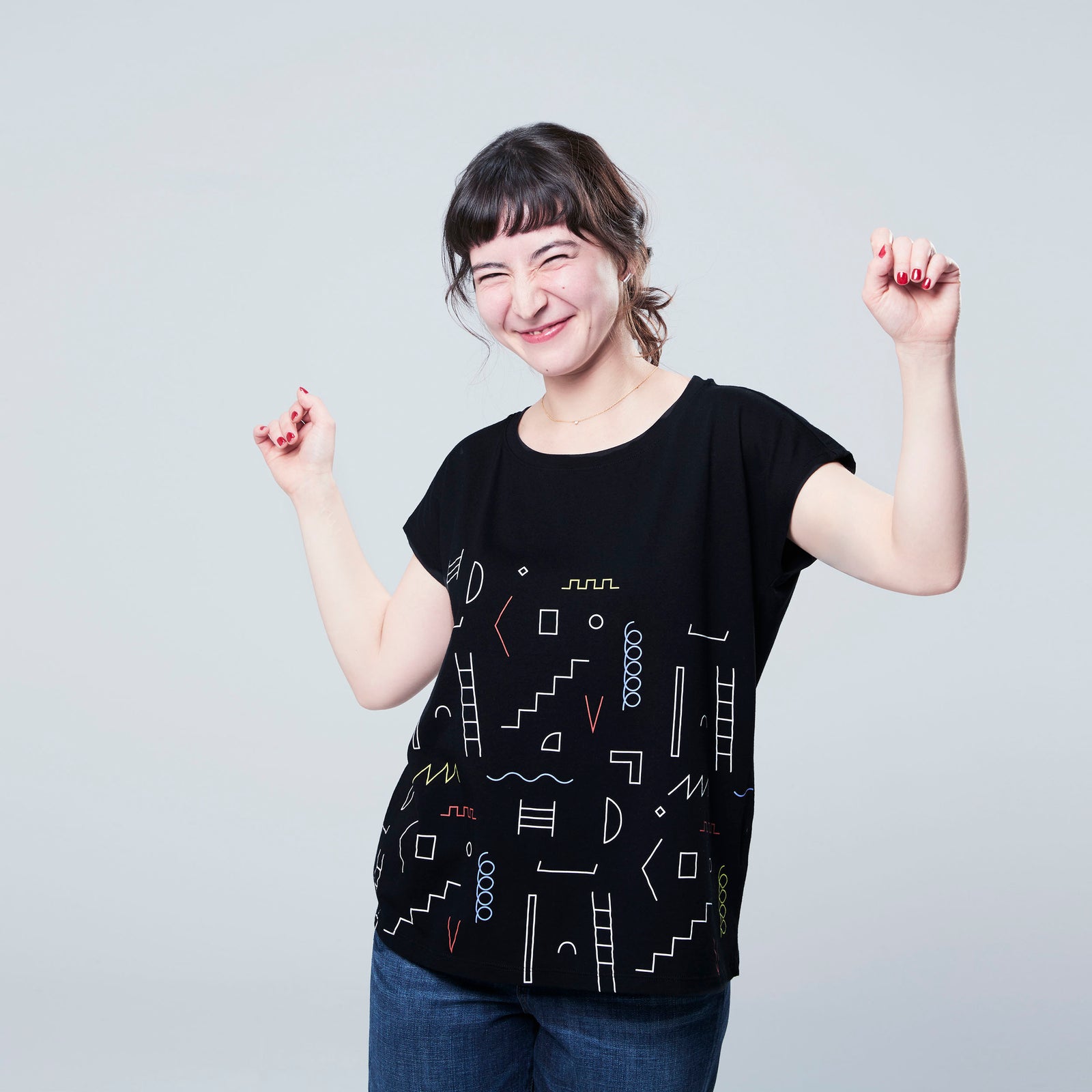 woman in black pattern t shirt arms in air