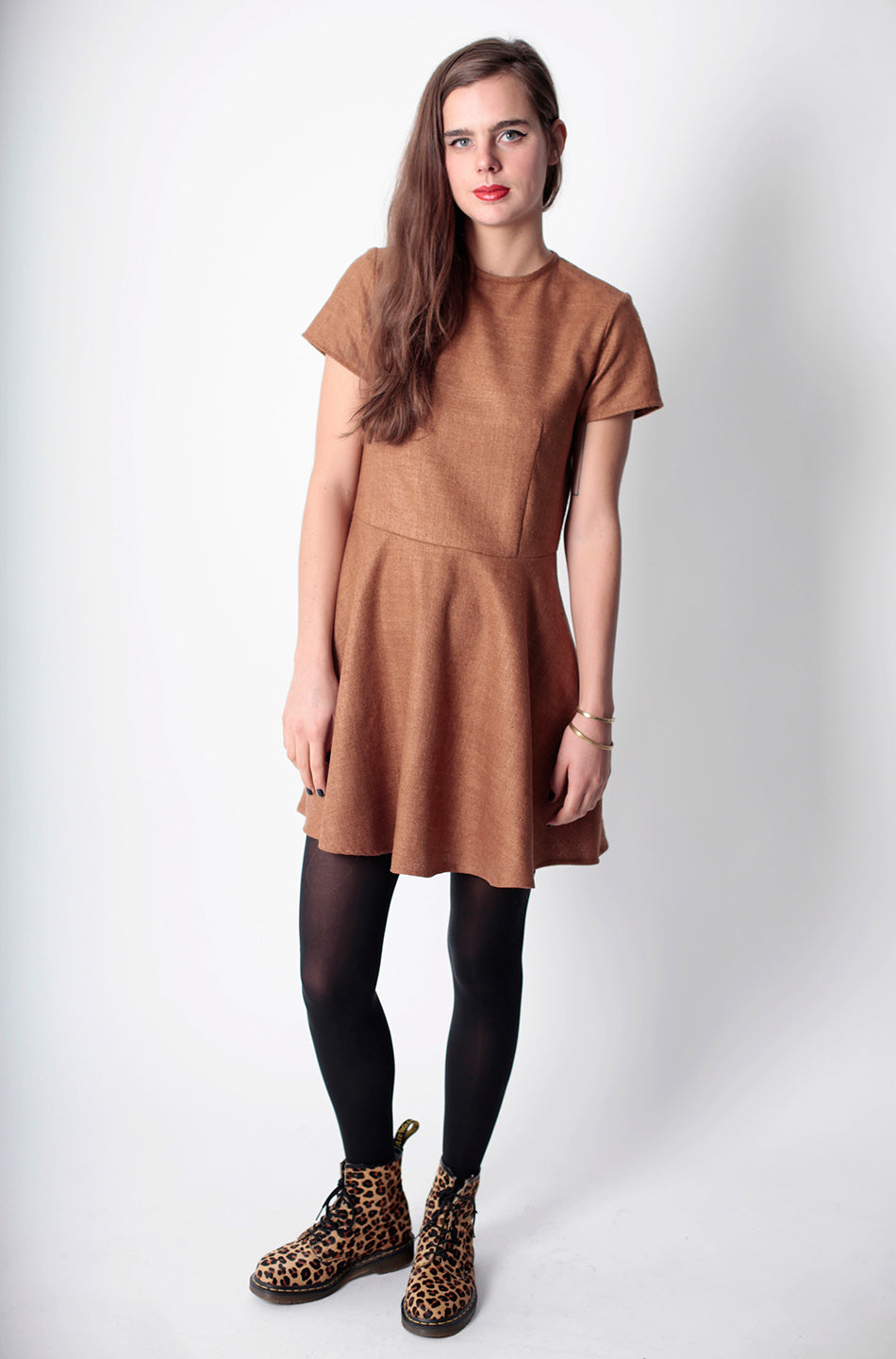 woman in fitted tan skater dres and cheetah boots