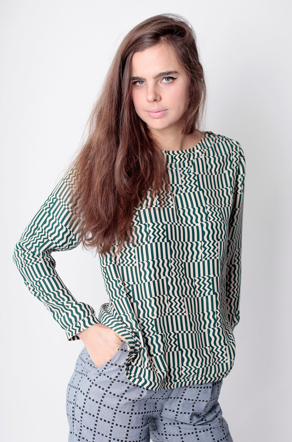 woman in green squiggle gris shirt long sleeve and grey grid pants