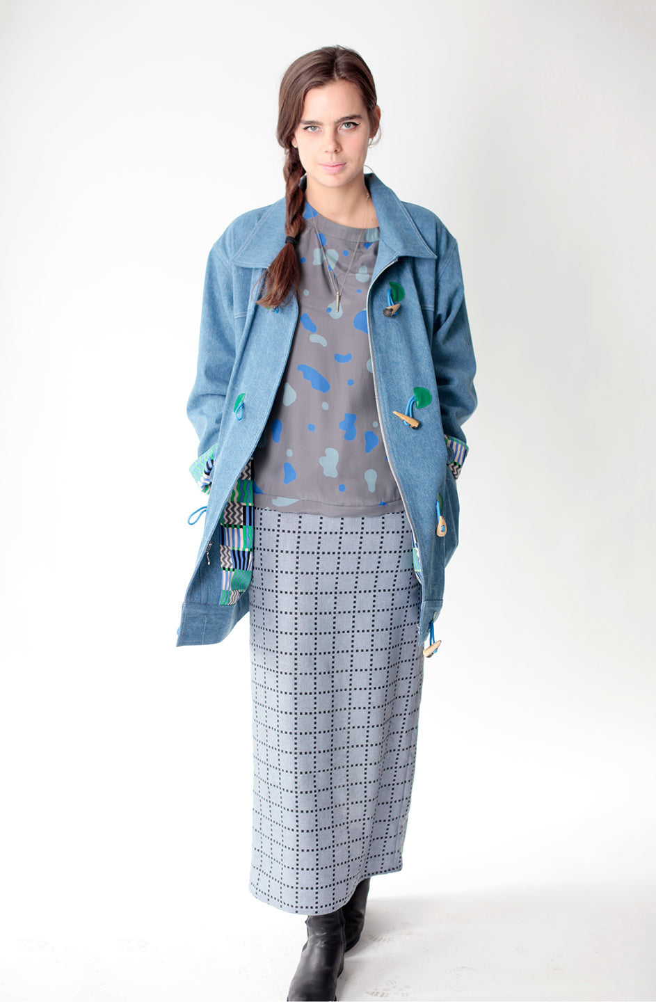 woman in ight denim raincoat with grey grid skirt and grey shirt with blue splotches