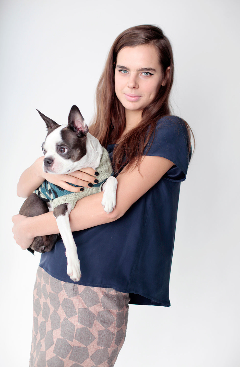 woman holding snips in navy shirt and grey/beige pattern pants