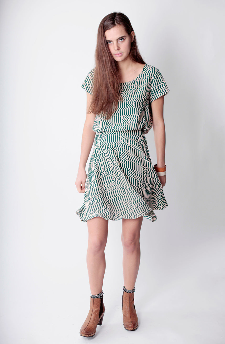 woman in flowy squiggle block green dress short