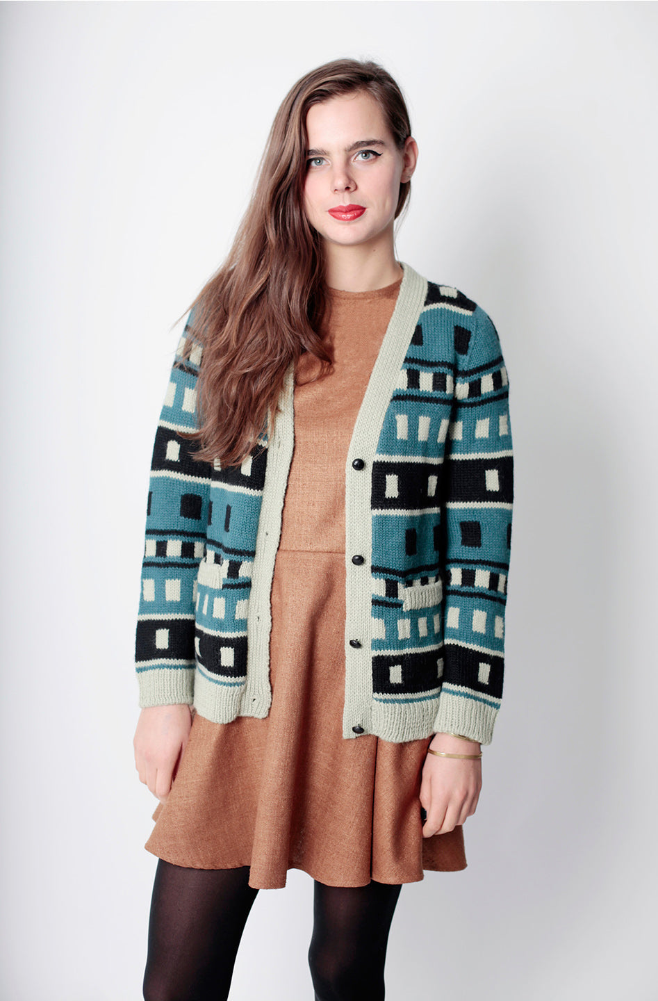 woman in green black and white square cardigan with tan skate dress