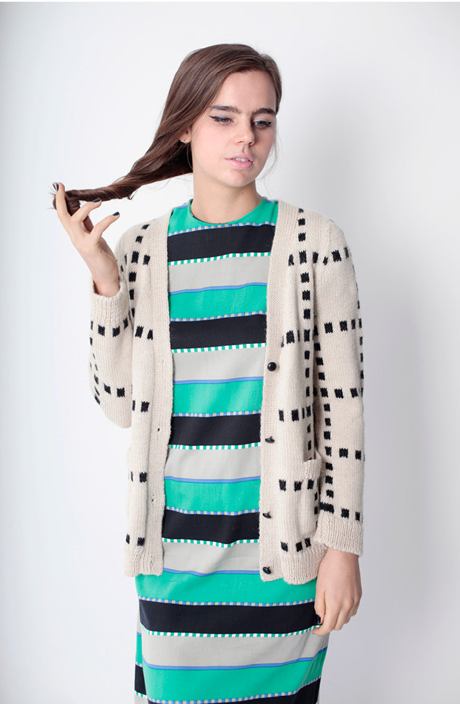 woman in green cardigan and green black white dress
