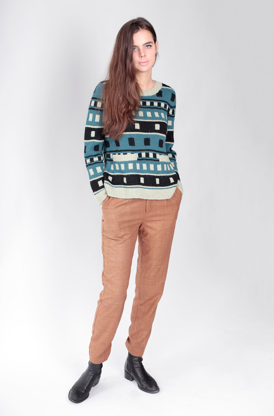 woman in blue blck and white block sweater and tan pants