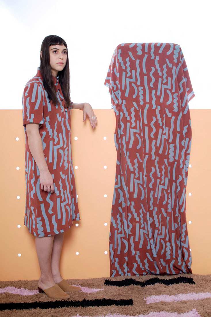 model in red button up mid dress with blue squiggles
