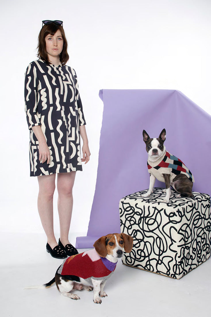 model in black dress with white squiggle pattern with snips and beagle in sweaters