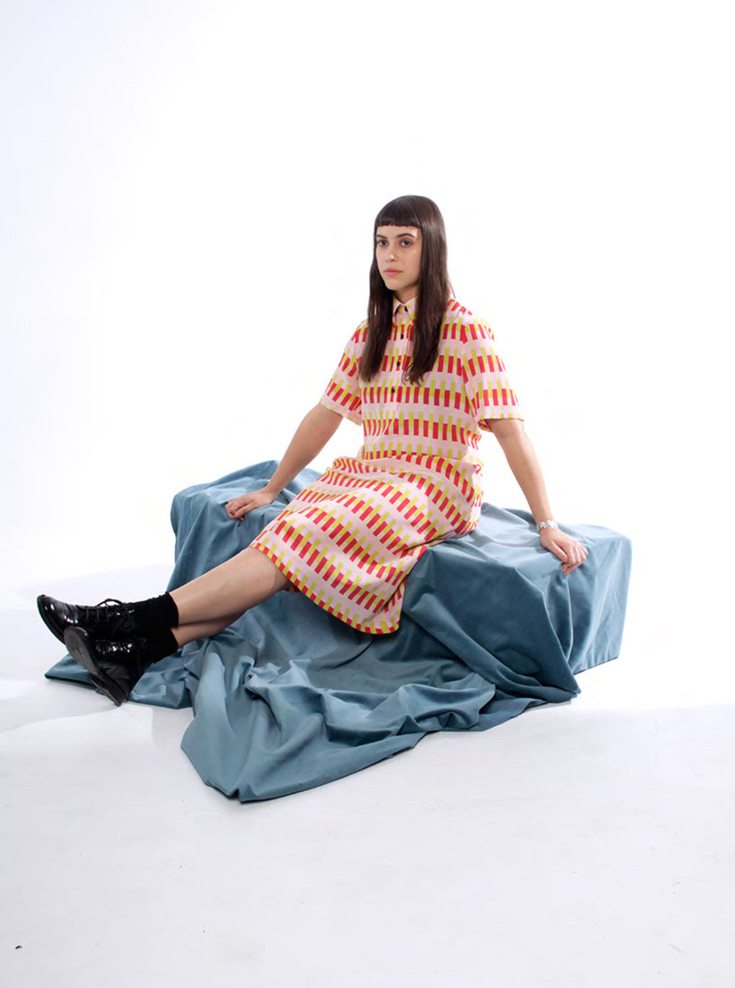 Model in button up pink, red and yellow dress