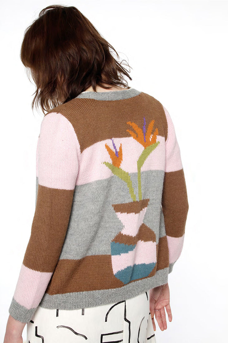 model in sweater that shows a bird of paradise flower