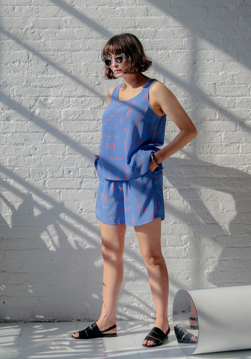 women in blue tank and shorts with red doodle line pattern