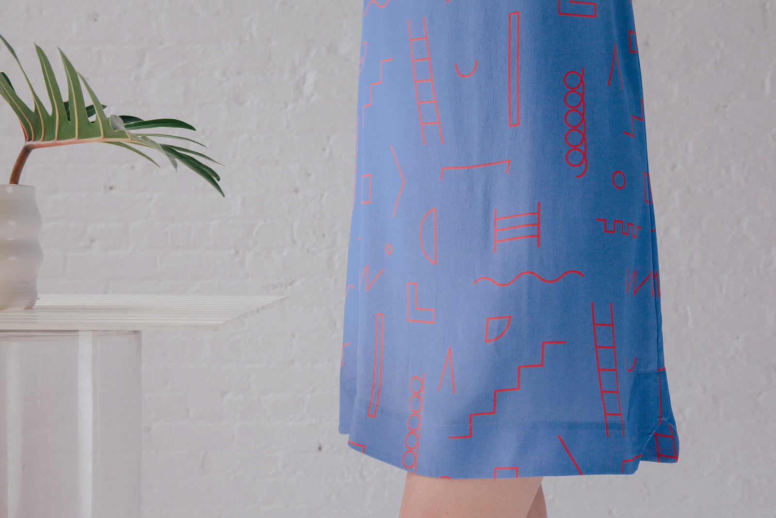 skirt detail of blue fabirc with red doodle line pattern