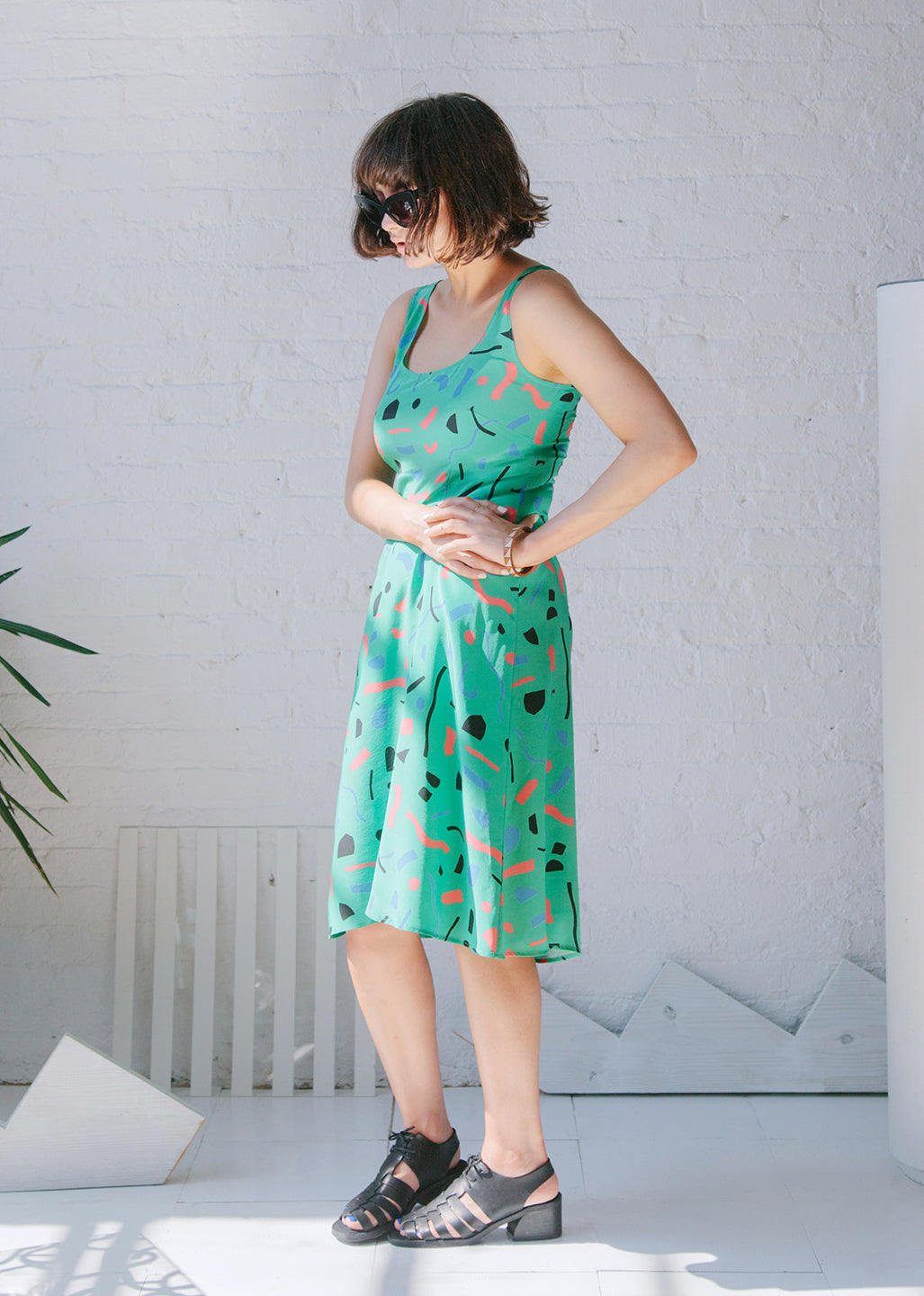 woman standing with green dress with cut out pattern