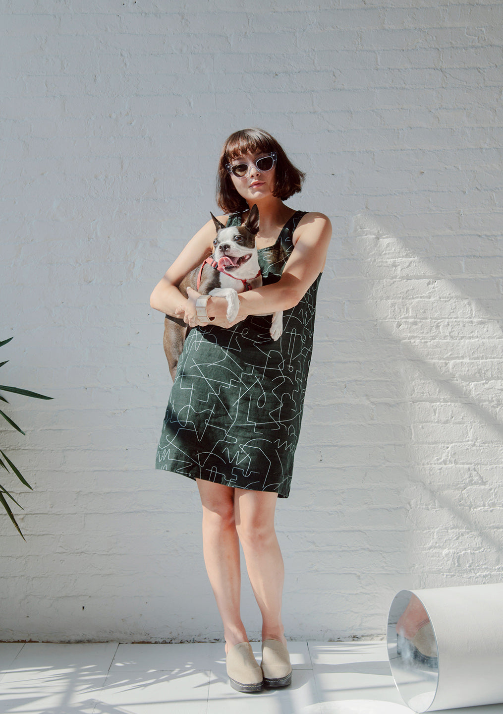 woman holding snips the dog with black dress and white line pattern