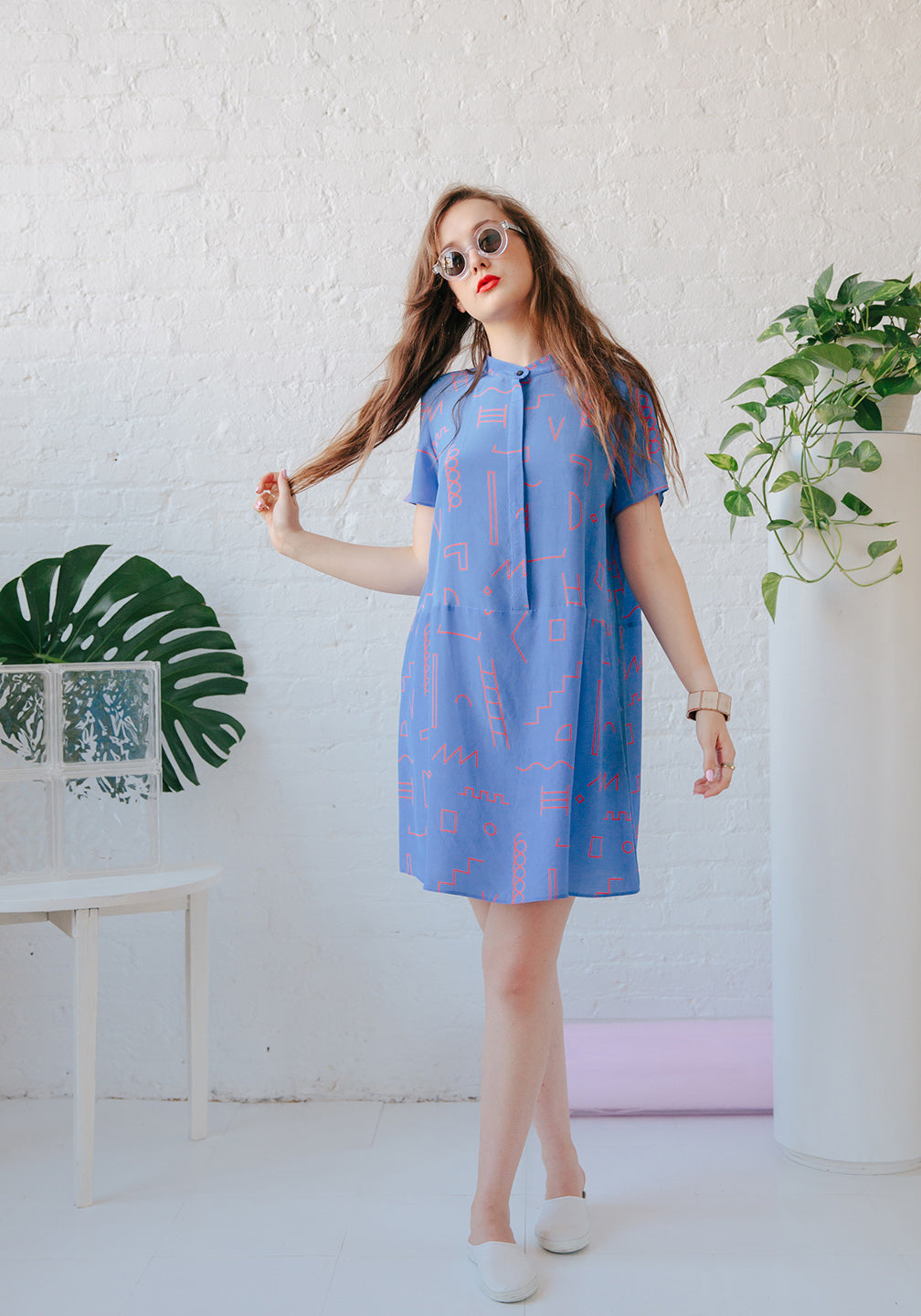 woman in blue dress with red doodle pattern with neck tie