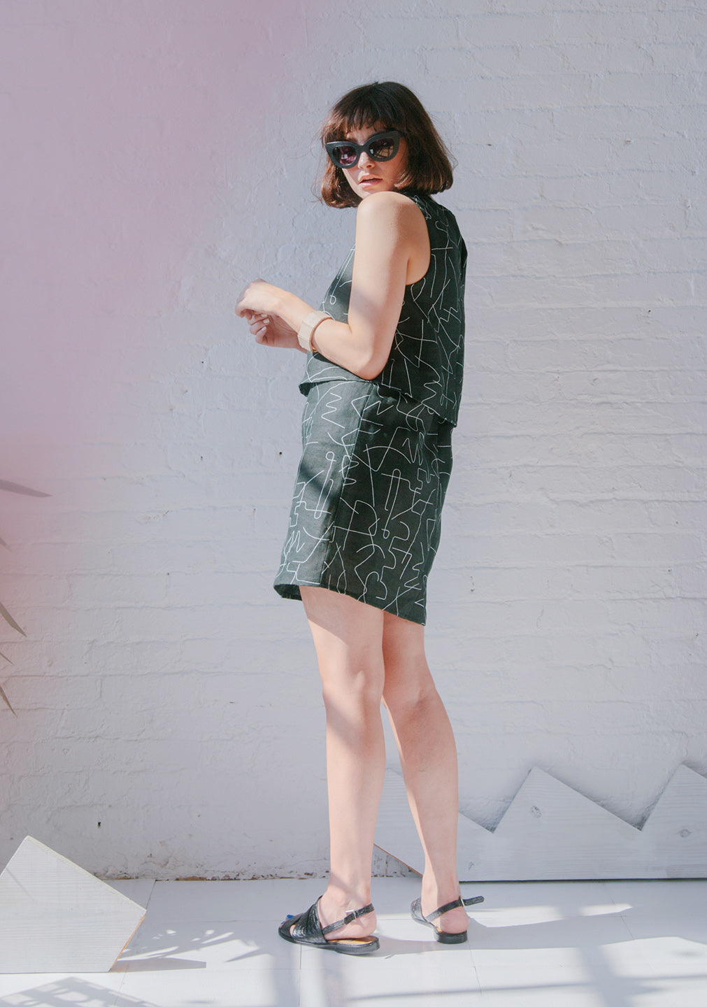 woman from behind in black short and tank with white line pattern