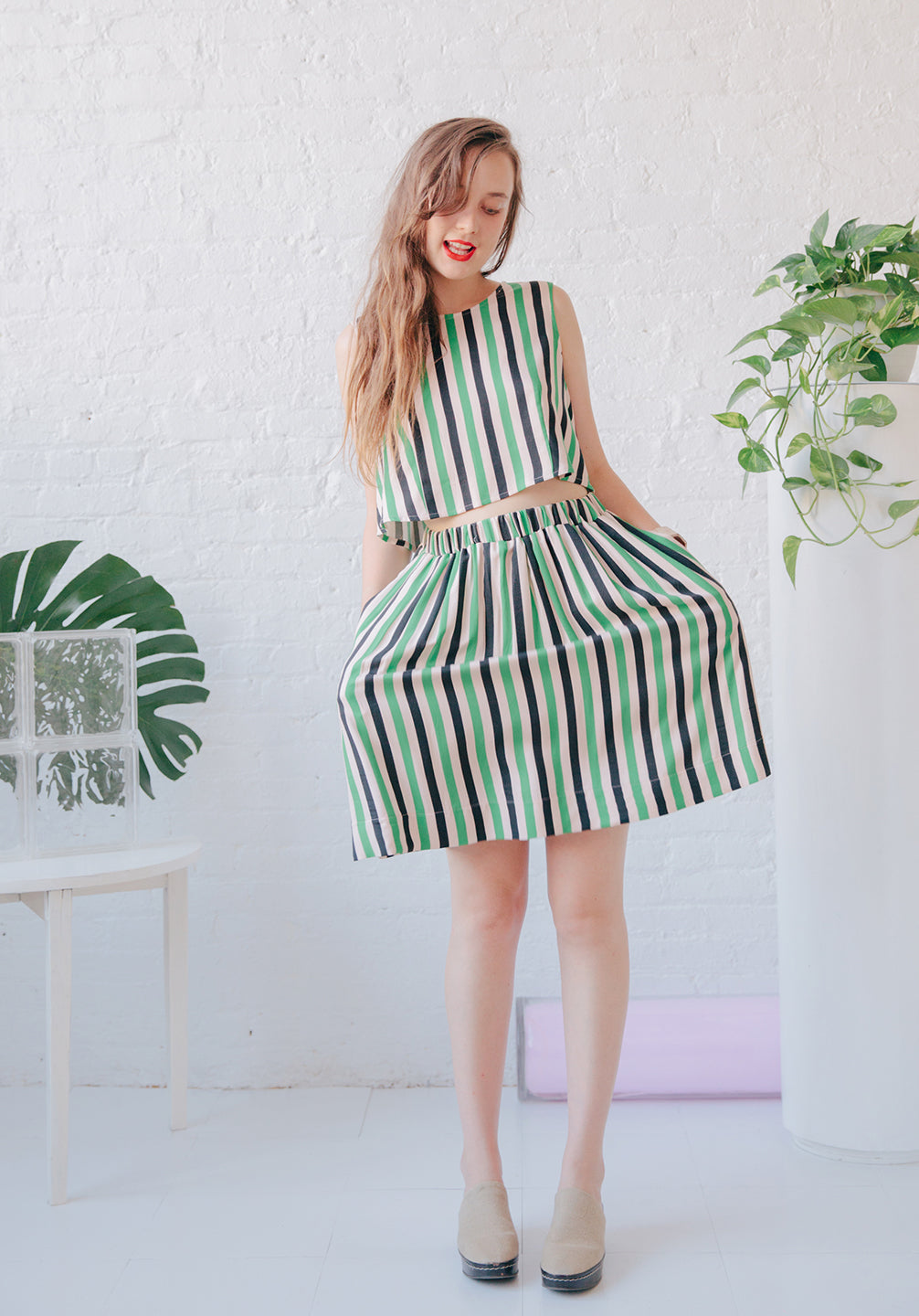woman in green black and white striped skirt and tank top