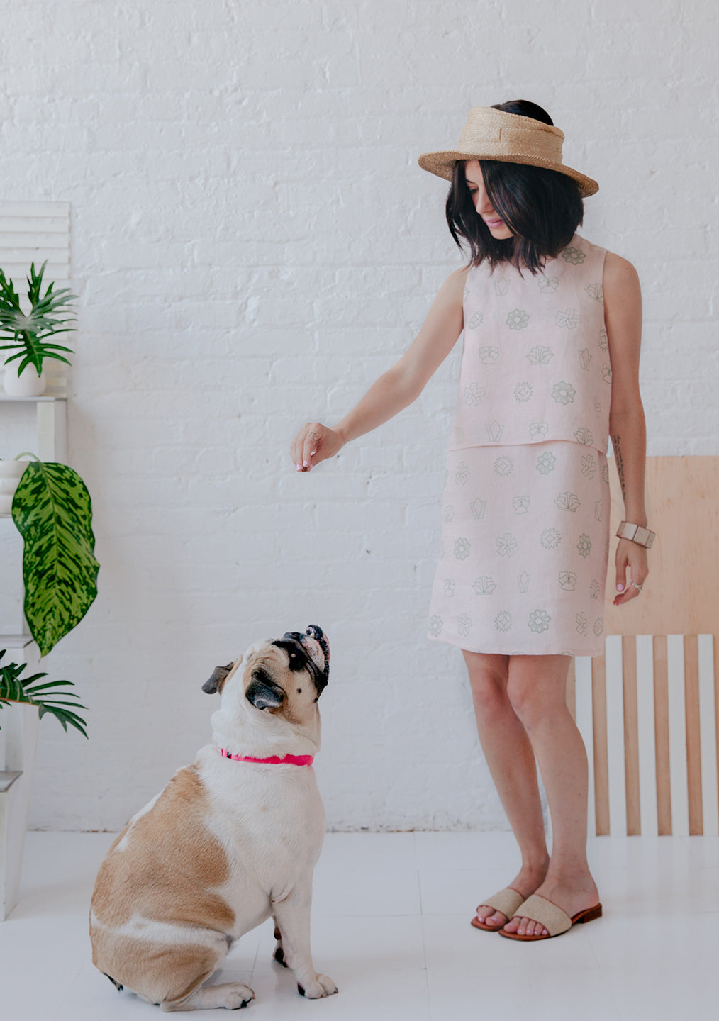 woman in visor in matching pink skirt and top with green flower pattern