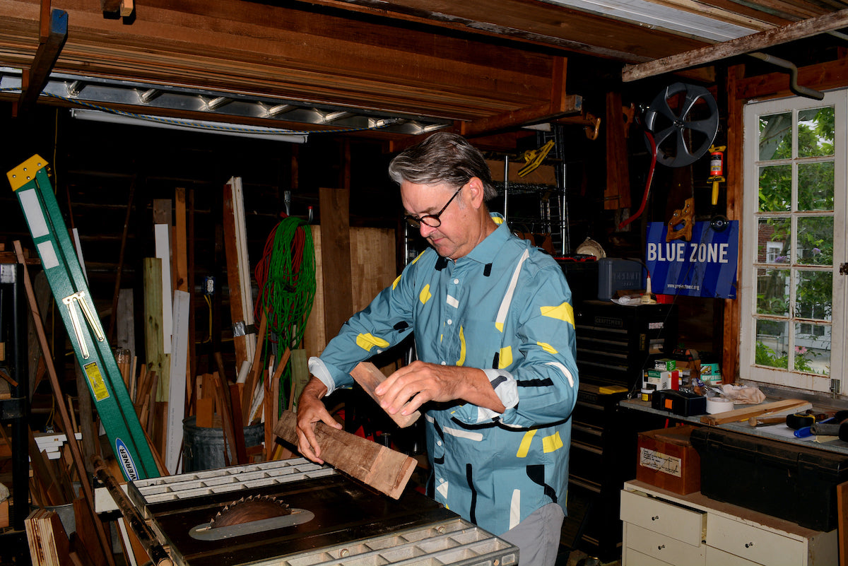 Ben in garage cutting wood in green button up