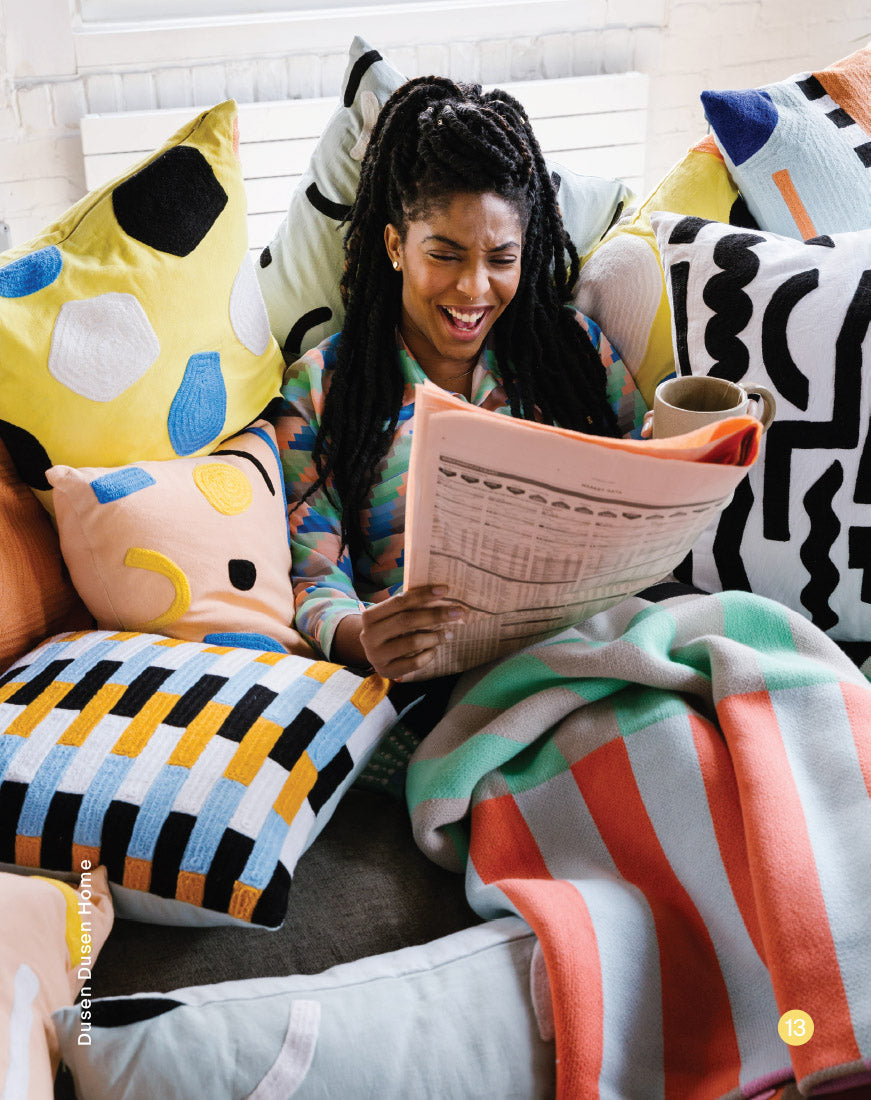 jessica williams under stripe blanket surrounded by pillows