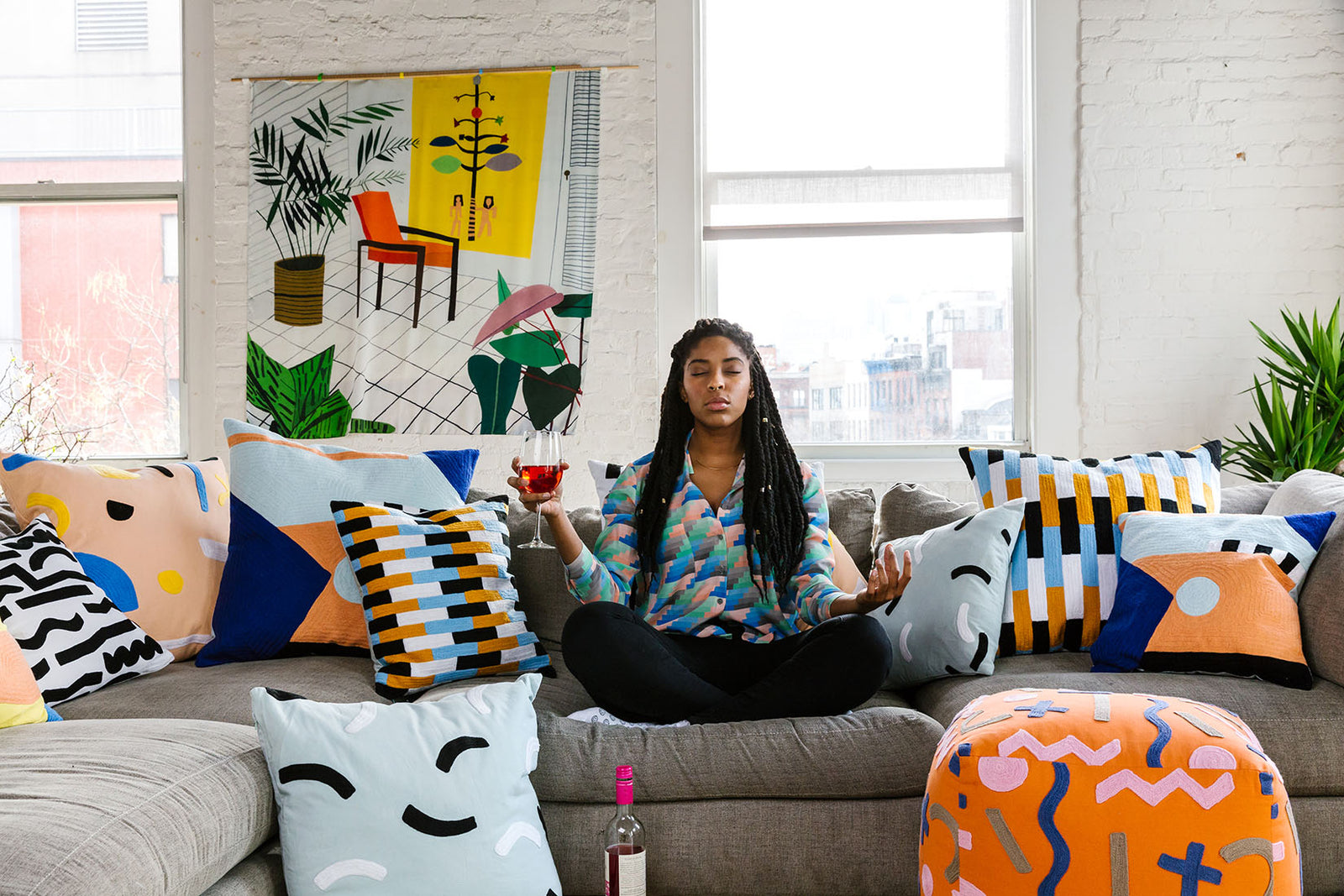 jessica meditating on couch with wine with pillows