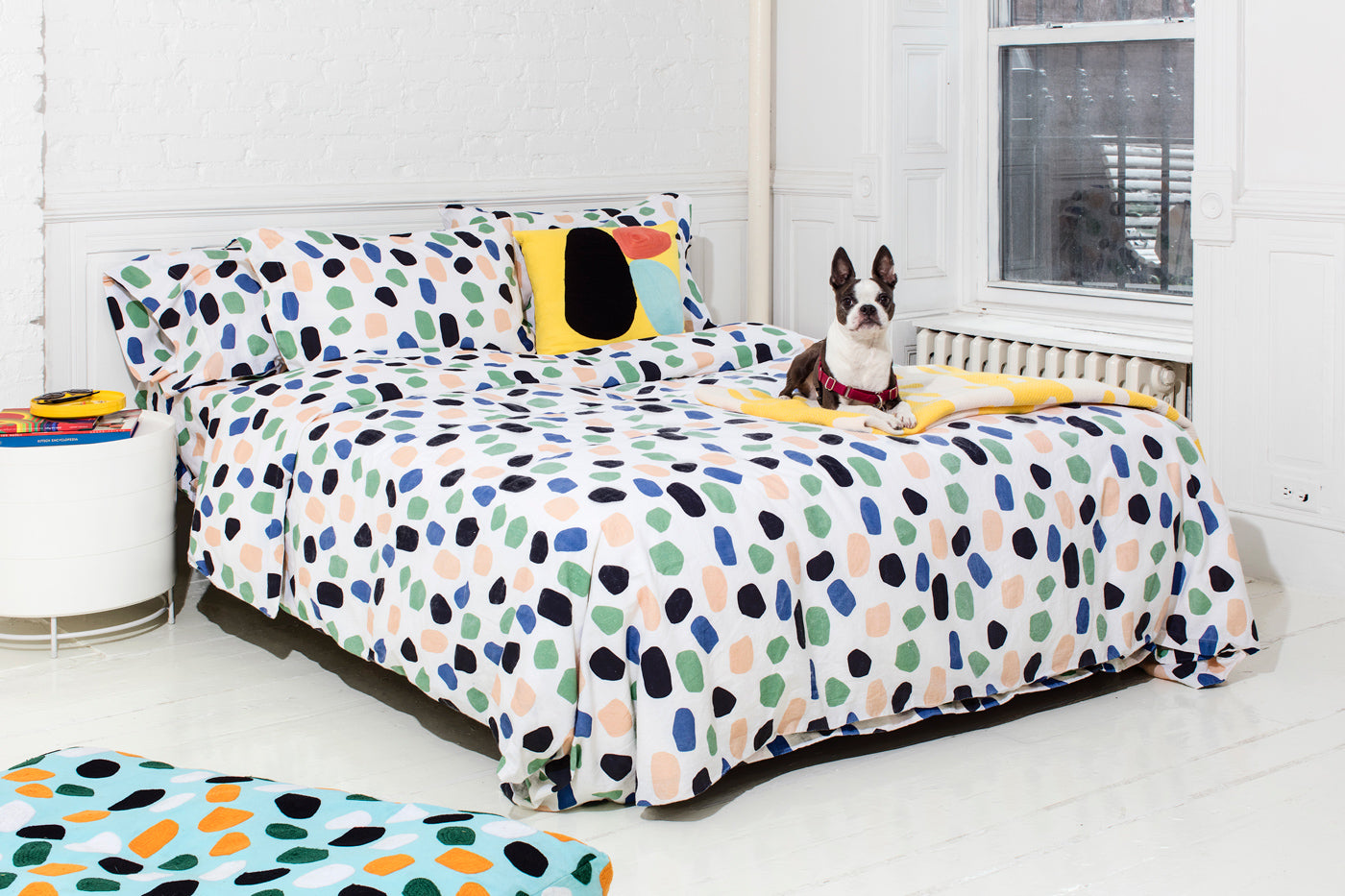 polka dot bedding on bed with dog and yellow pillow