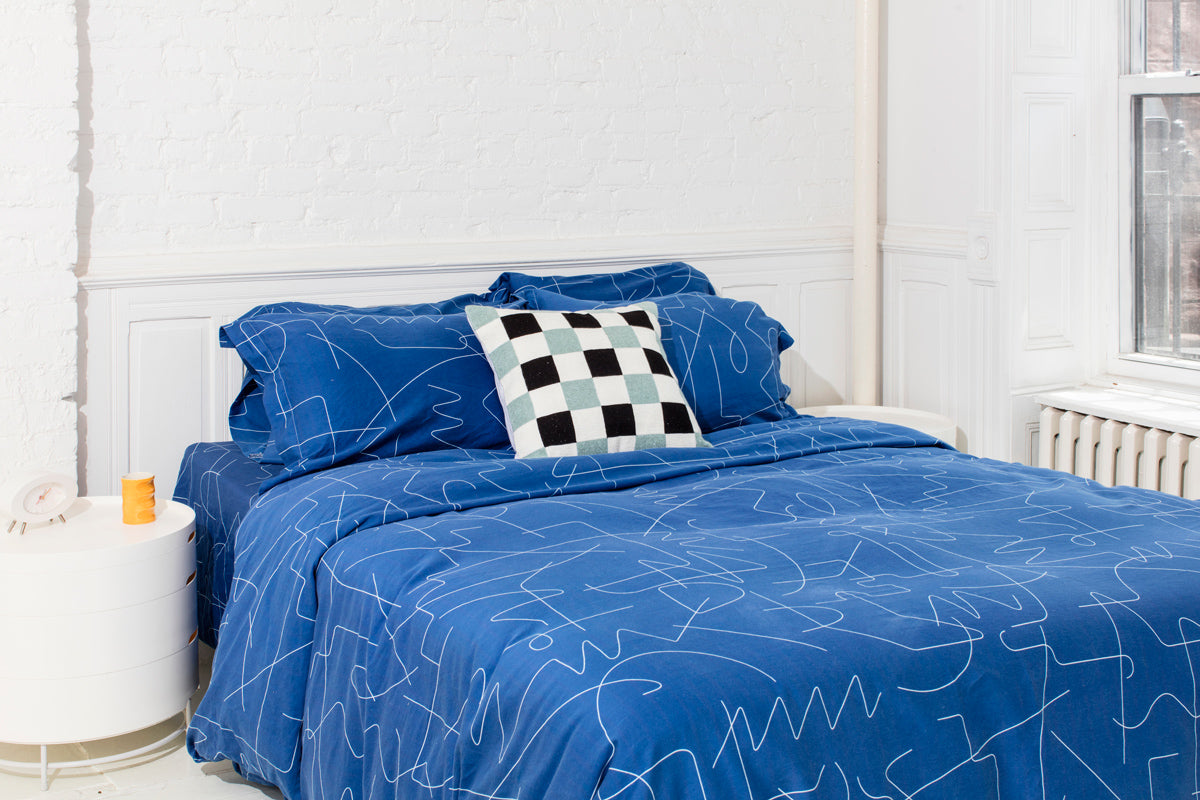 blue bedding in white room