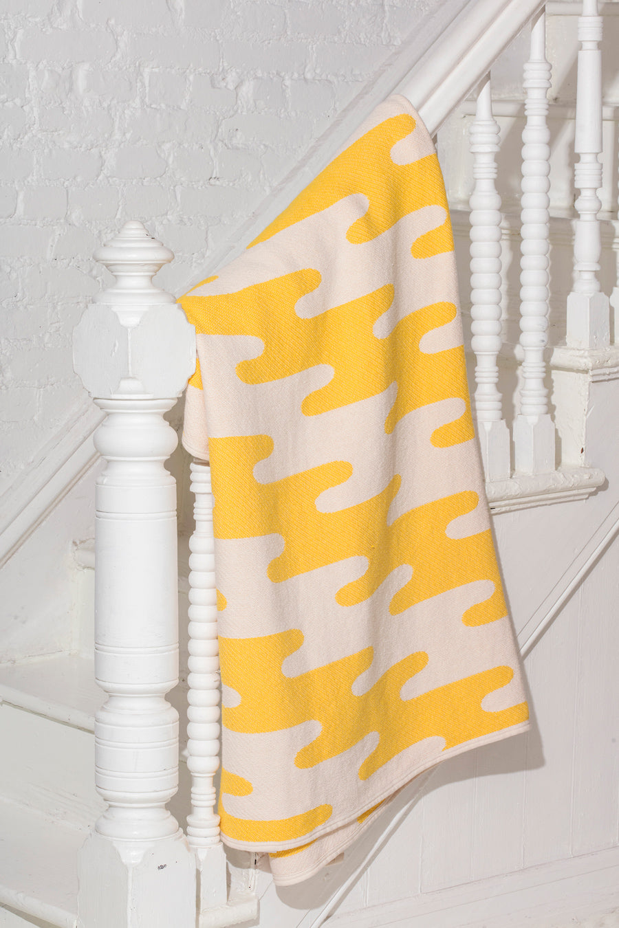 yellow towel on white banister
