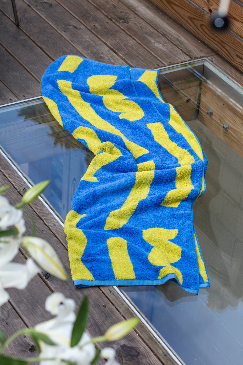 blue and yellow pattern towel on wooden deck