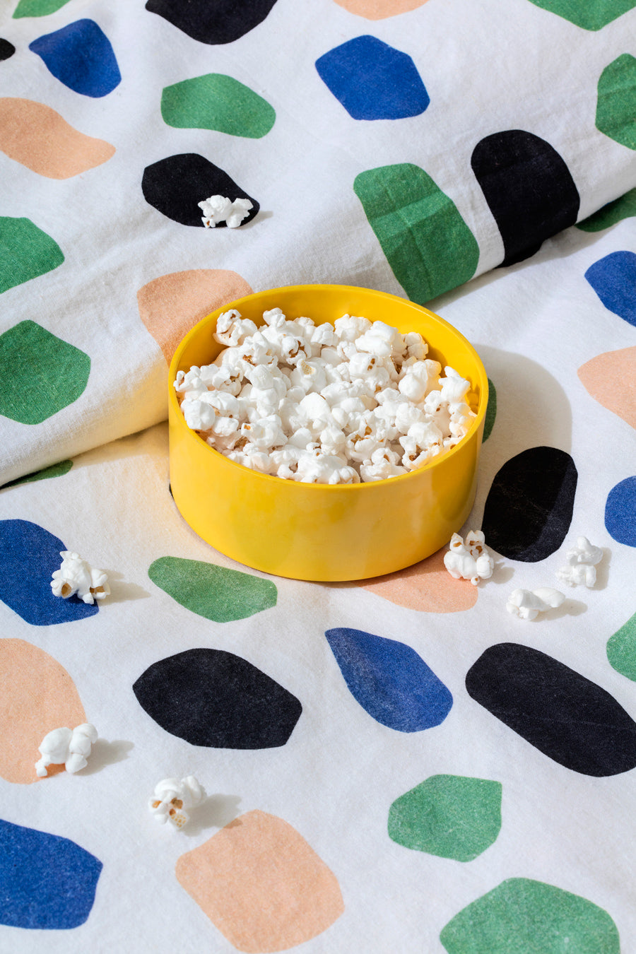 yellow bowl of popcorn on polka dot bedding