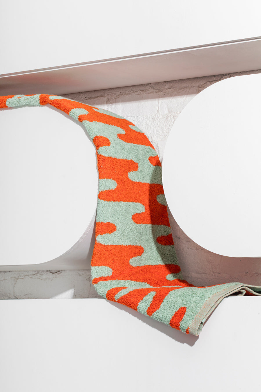 orange and green towel on shelf