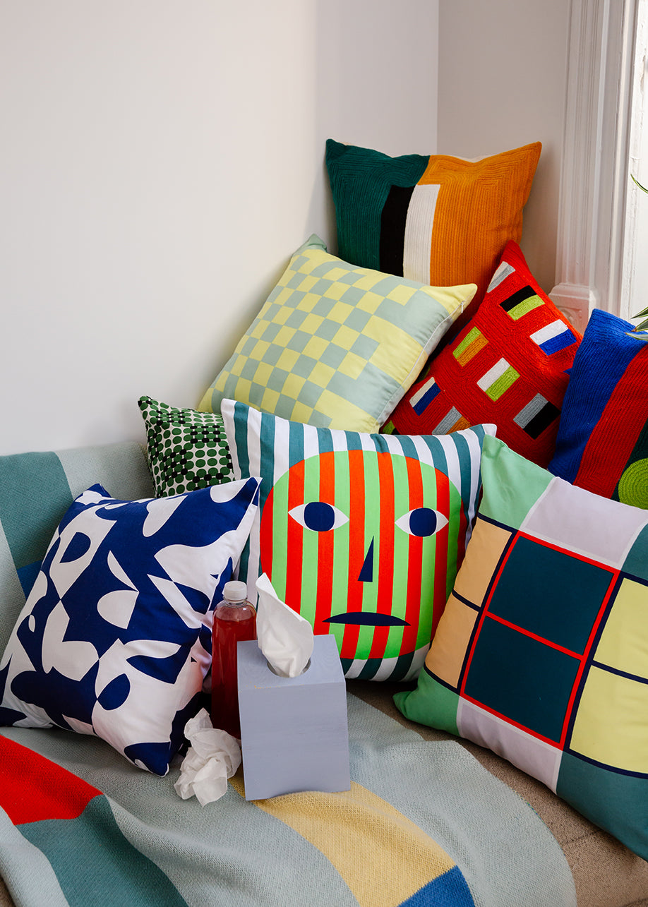 pile of colorful pillows with tissue box