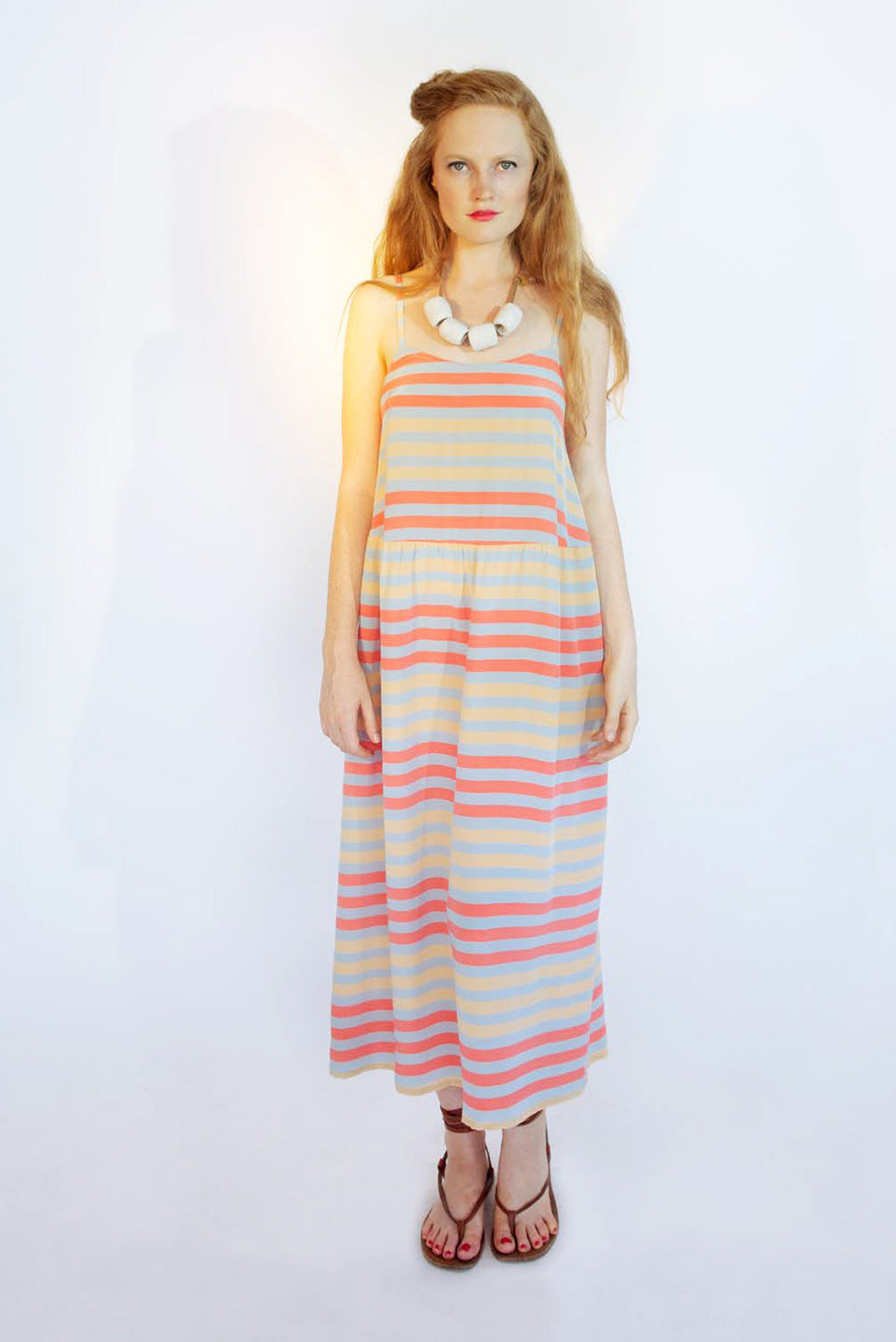 woman in strap sun dress orange and red pattern