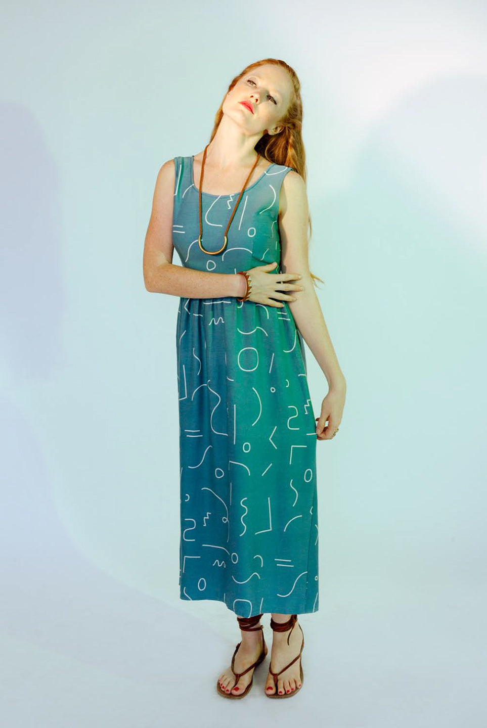 woman in green dress line pattern hand over stomach