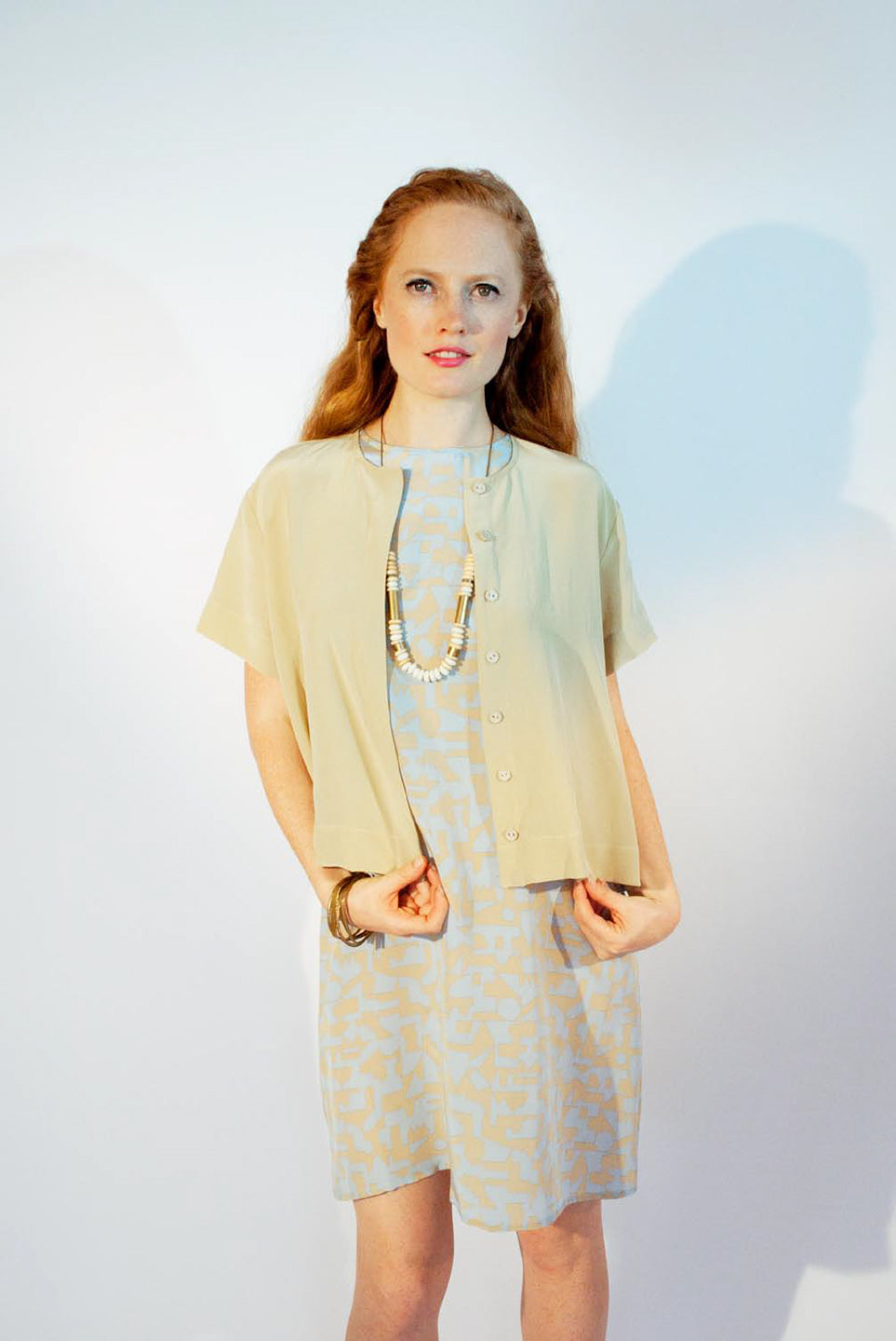woman in tan short sleeve top and pastel blue beige pattern dress