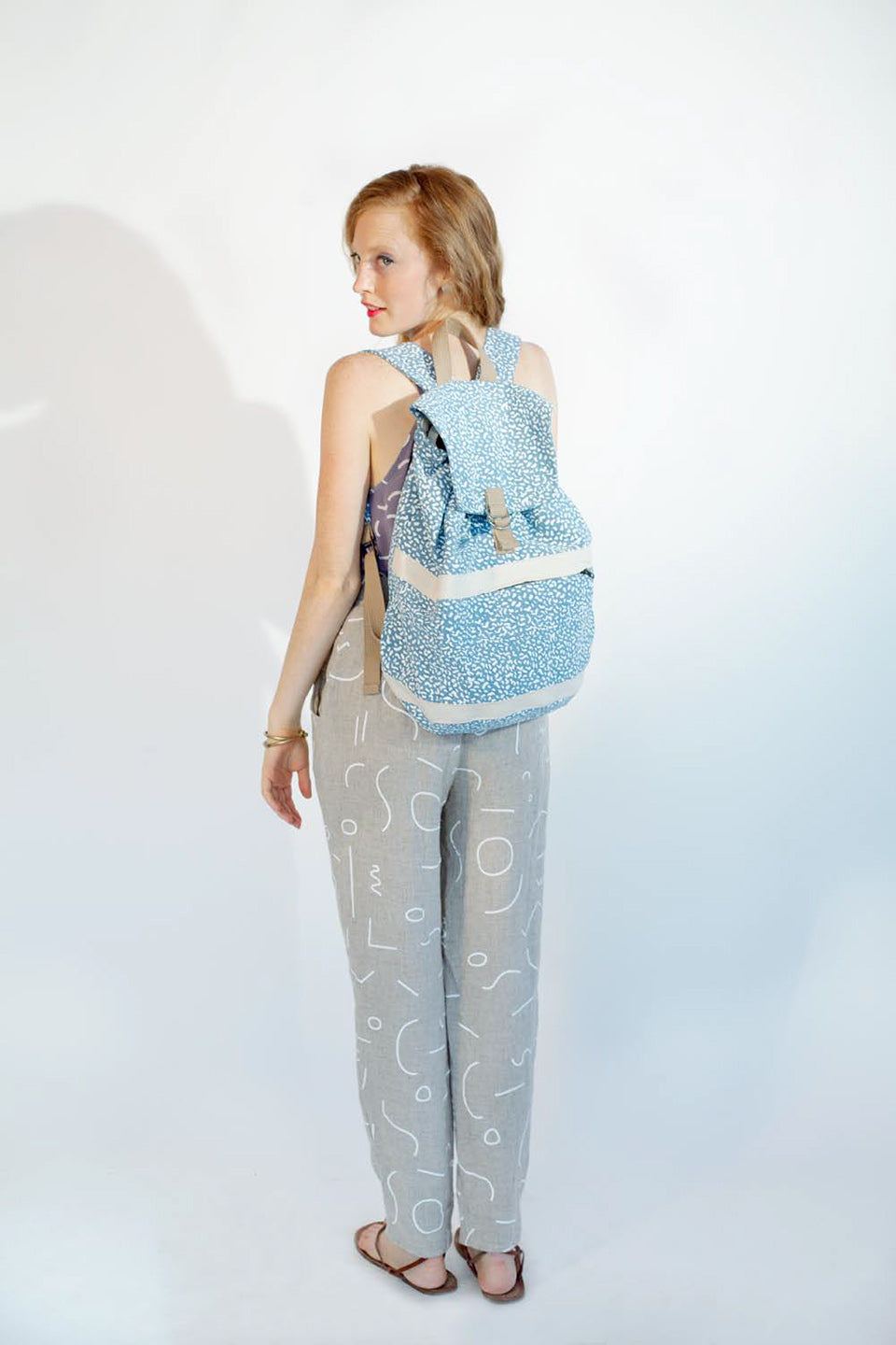 blue satchel backpacke with grey pants line pattern