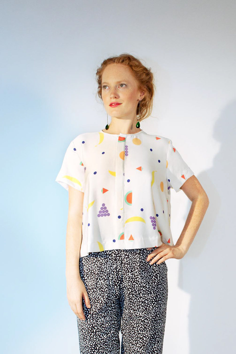 woman in fruit pattern shirt and black splatter pants
