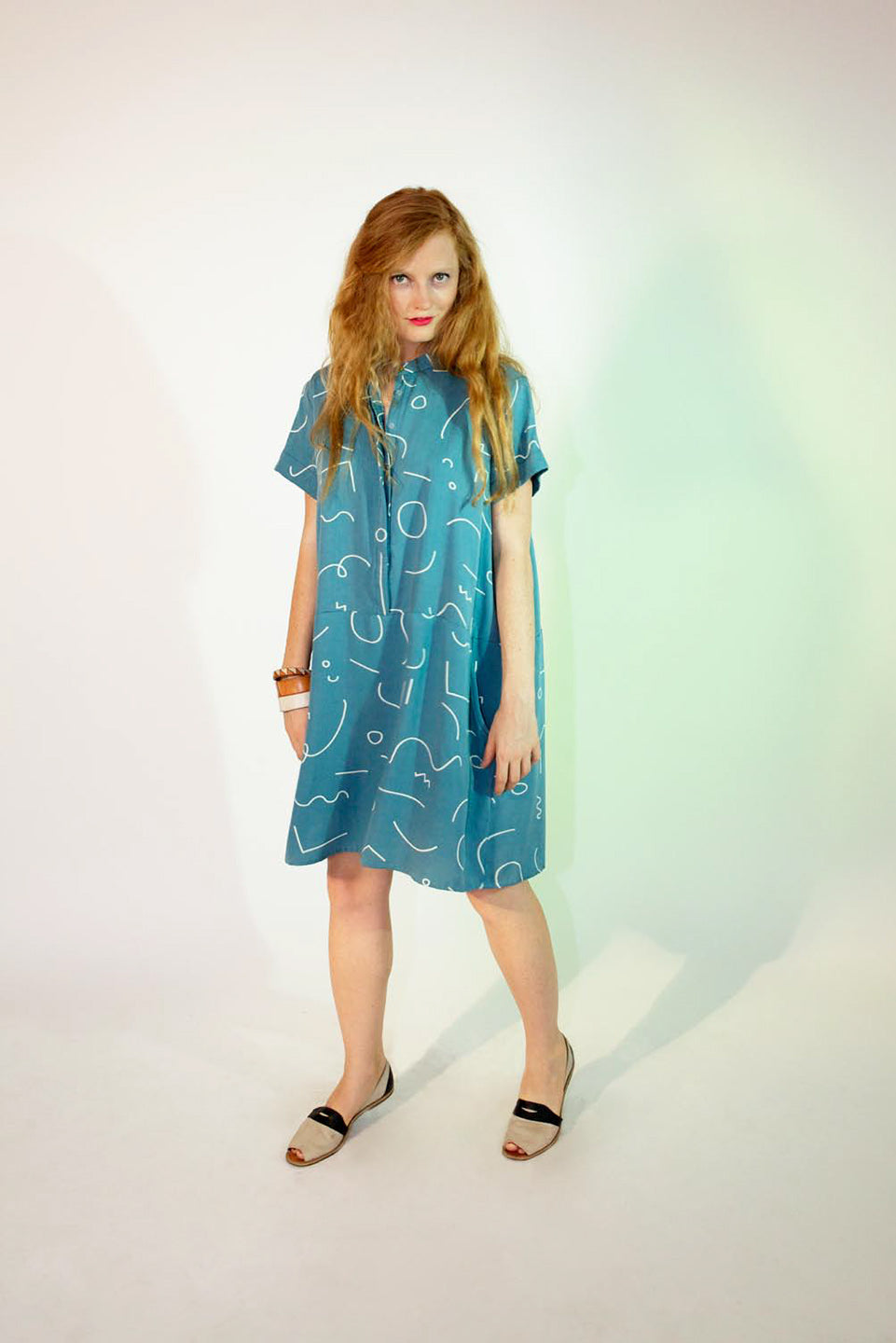 woman in blue shift dress button up line pattern denim blue