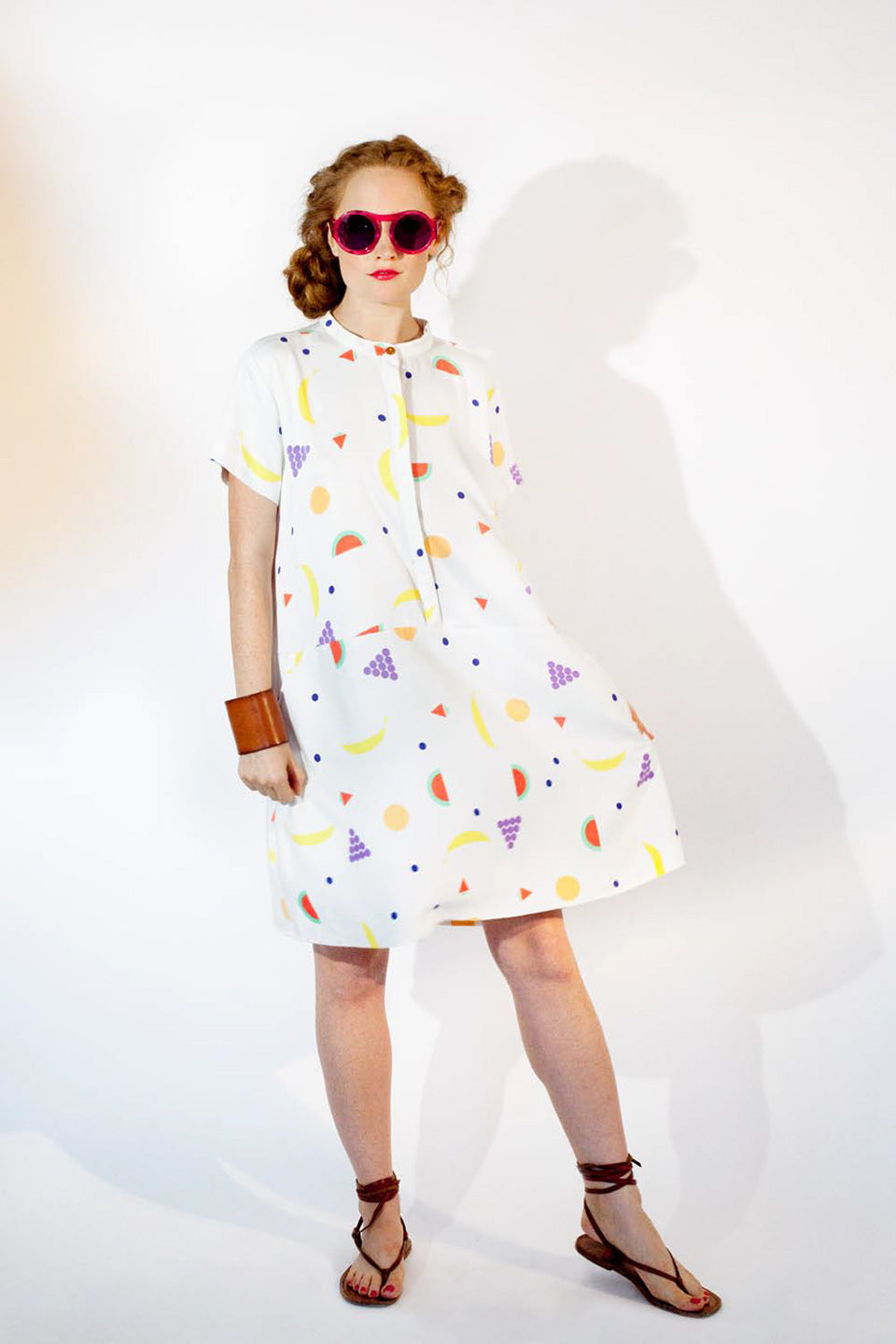 woman in fruit pattern dress with red round sunglasses