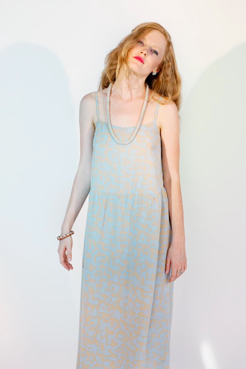 woman in strappy sun dress beige and baby blue cunky necklace