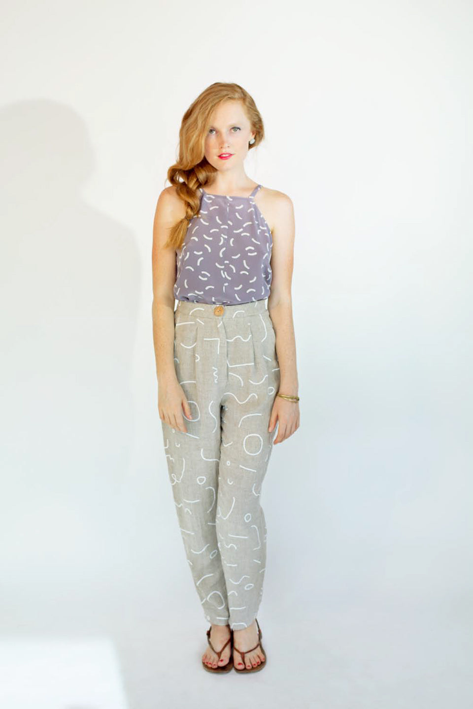 woman in blue halter top with curve pattern and grey pants with line pattern